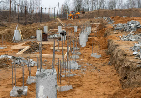 Photo of construction metal rods in concrete pillars against the background of a construction site...