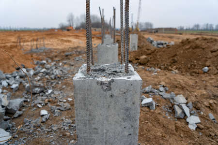 Photo of construction metal rods in concrete pillars against the background of a construction site on the street.の写真素材