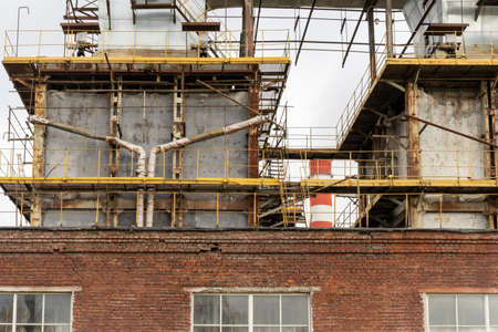 Photo of metal pipes next to a thermoelectric plant with big chimneys. Factory. Brick building.の写真素材