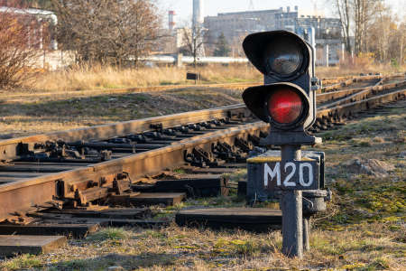 Photo of burning red light at a traffic light at the background of a railway. Train concept.の写真素材