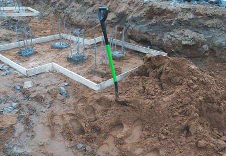 photograph of a shovel at a construction site near the foundation elements.の写真素材