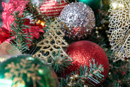 Photo of silver and red shiny Christmas balls on a green Christmas tree. New Year.の写真素材