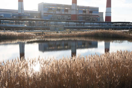 Reflection of pipes heat power plant in water.の写真素材