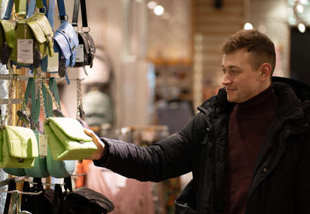 Photo of a young man choosing a gift for his beloved wife or girlfriend
