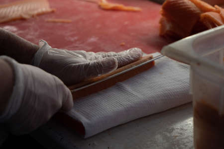 Chef's hands with a knife close-up. Fillet of red fish