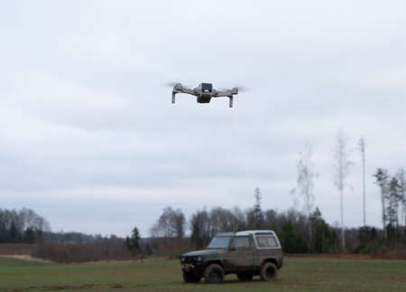 Photo of a drone over the field filming a jeep