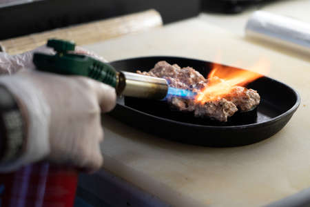 chef uses a gas gun to bake the rolls.の写真素材