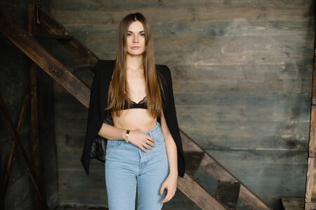 Portrait of a young, attractive student girl in blue jeans. She is serious and standing in the sun...