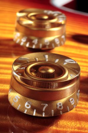 Close up of volume and tone knobs on a Gibson Les Paul electric guitar