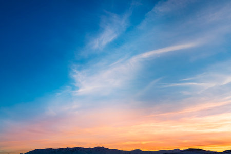 Sunset over the mountains in the background of a blue sky.の写真素材