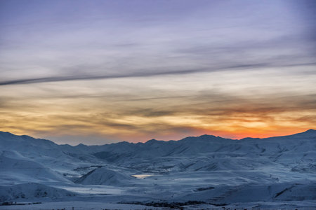 Sunset in the mountains. Beautiful winter landscape with snowy mountains.の写真素材