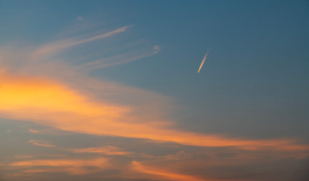 Sunset sky with clouds and contrail. Abstract background and texture.の写真素材