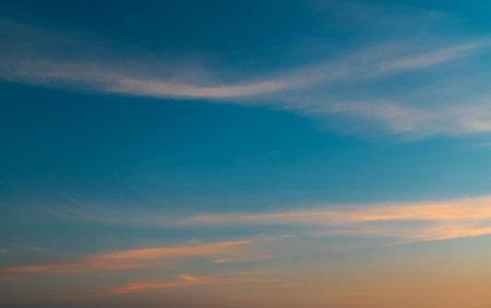 Sunset sky background with tiny clouds. Blue and orange colors.の写真素材