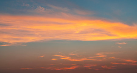 Sunset sky background with orange and blue colors. Beautiful nature scene.の写真素材