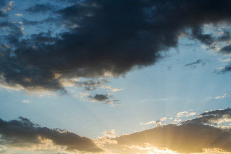 Sunset sky with clouds and sunbeams, natural background.の写真素材