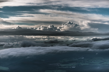 Clouds from above  A dramatic evening sky above green hilly landscape  The photograph was taken at 4 000 feet elevation and shows different layers of clouds の写真素材