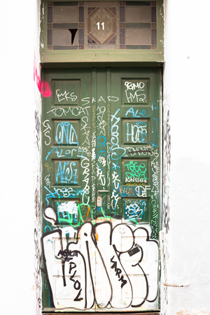 A building door with graffitis and white wallのeditorial素材