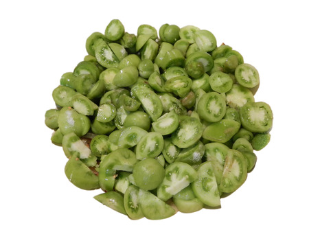 Heap of cut small green tomatoes on white backgroundの写真素材