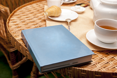 cup of tea croissant book on tableの写真素材