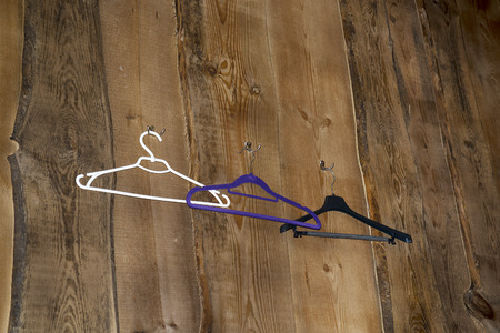 a hanger on a dark and wooden wallの写真素材