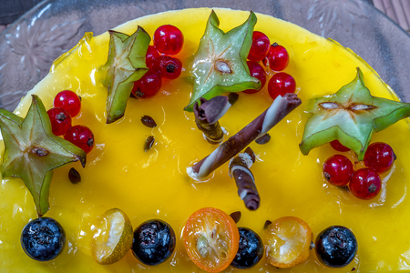 yellow jelly cheesecake with berries on plateの写真素材