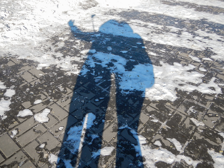 shadow of two people on the snowの写真素材