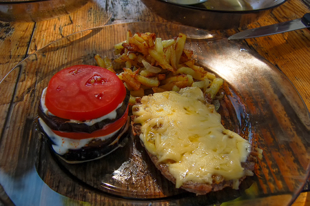 Aubergines tomatoes French fries meet with cheeseの写真素材