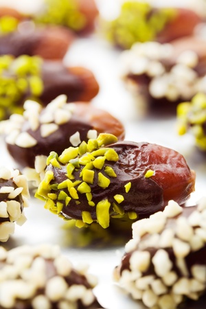Homemade pralines with dates, nut slivers and chocolate on aluminum foilの写真素材
