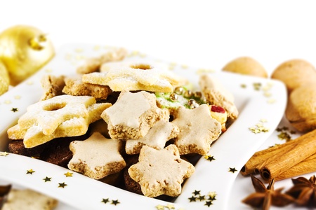 Assortment of homemade Christmas cookies on a plate decorated with golden Christmas balls and starsの写真素材