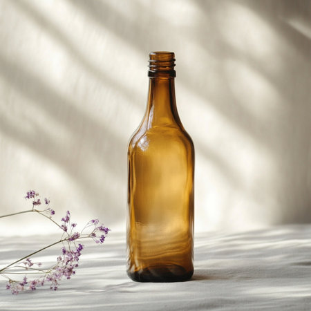 A minimalistic glass bottle standing on a smooth, softly blurred background with ample empty space for text or branding. Perfect for packaging design presentations, advertising mockups, or cosmetic and beverage product templates. This image conveys clarity, elegance, and modern simplicityの写真素材
