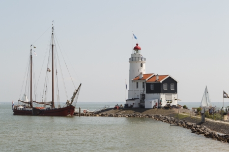 An old wooden sailboat visits the "Paard of Marken" lighthouse in Marken, the Netherlands.のeditorial素材