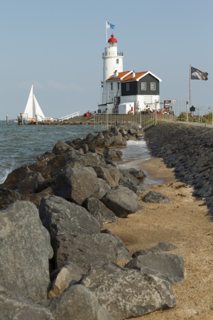 A sailboat sails past the "Paard of Marken" lighthouse in Marken, the Netherlands.のeditorial素材
