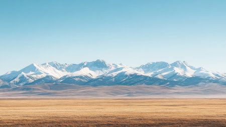 A snow-capped mountain range stretching across the horizon under a clear winter sky.の素材