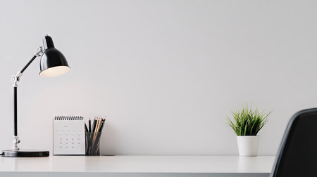A modern office desk with a neat arrangement of office supplies, a desk lamp, and a calendar. The empty space around the items allows for clear copy placement.の素材