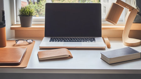A modern desk featuring a sleek laptop, a set of notebooks, and a plant. The clean design and open space around the desk provide a great area for copy.の素材