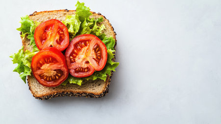 A vibrant sandwich featuring fresh tomatoes and crisp lettuce on toasted bread. Perfect for a healthy meal or snack, showcasing simple ingredients.の素材