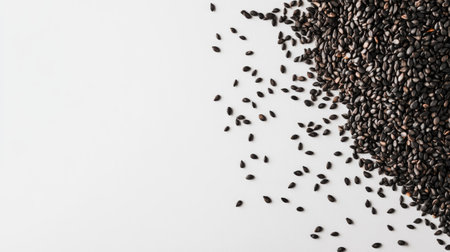 A close-up view of black sesame seeds arranged in a pile on a clean white background, showcasing their rich texture and natural appeal for culinary uses.の素材