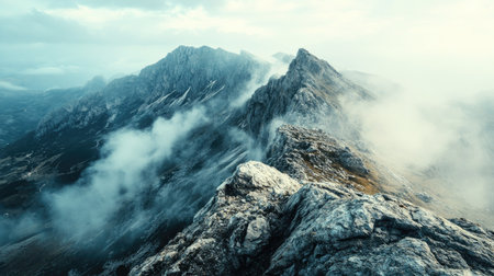 Flat lay of a rocky mountain peak with mist rolling through the valley below, with plenty of empty sky above for copy space, perfect for nature-themed designs.の素材