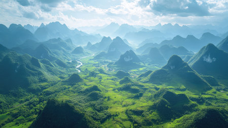 Top view of a green valley surrounded by towering mountain peaks, with ample sky above for copy space, ideal for outdoor adventure promotions.の素材