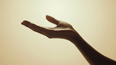 A graceful silhouette of a hand against a soft, warm backdrop, evoking elegance and serenity. Perfect for showcasing beauty and minimalism in art.の素材