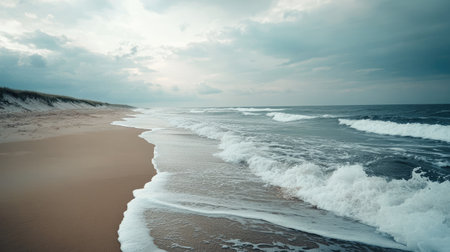 Wide shot of a beach with rhythmic waves breaking against the shore, with a peaceful, tranquil atmosphereの素材