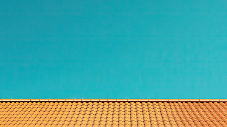A close-up view of a traditional orange clay roof against a bright blue sky. This image captures the unique architecture and vibrant colors typical of Mediterranean designs.の素材