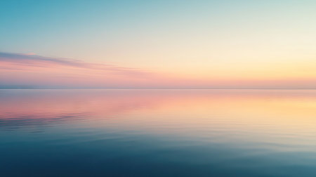 A tranquil lake reflecting the colors of the sunrise, with space above the horizon for adding text.の素材