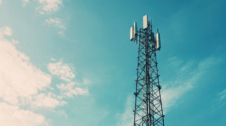 A wireless communication tower with a clear sky background, leaving ample space above for adding copy.の素材