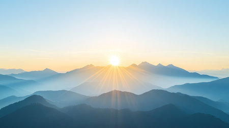 The sun rising behind a mountain range with a serene landscape, leaving plenty of open sky for text.の素材