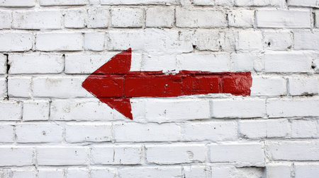 A red arrow pointing to the left against a white brick wall background, representing urban design or a casual,の素材