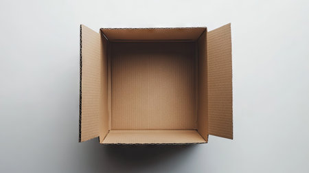 A cardboard box with slightly open flaps, isolated on a white background, perfect for moving, storage, or shipping-related stock photosの素材