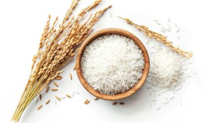 Top view of white Jasmine rice in a wooden bowl, with paddy rice and an ear of rice, isolated on white. Great for culinary and agricultural displays.の素材