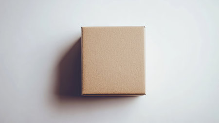 Top-down view of a closed cardboard box isolated on a white background, ideal for minimalist design, packaging, and shipping concept photographyの素材