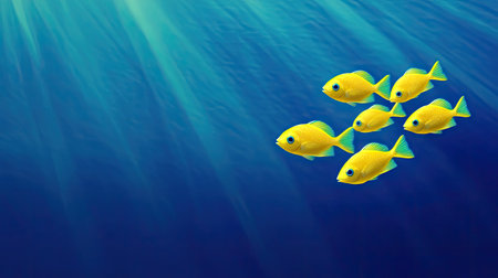 A school of electric yellow tang fish swimming in harmony against a deep blue ocean backdrop.の素材
